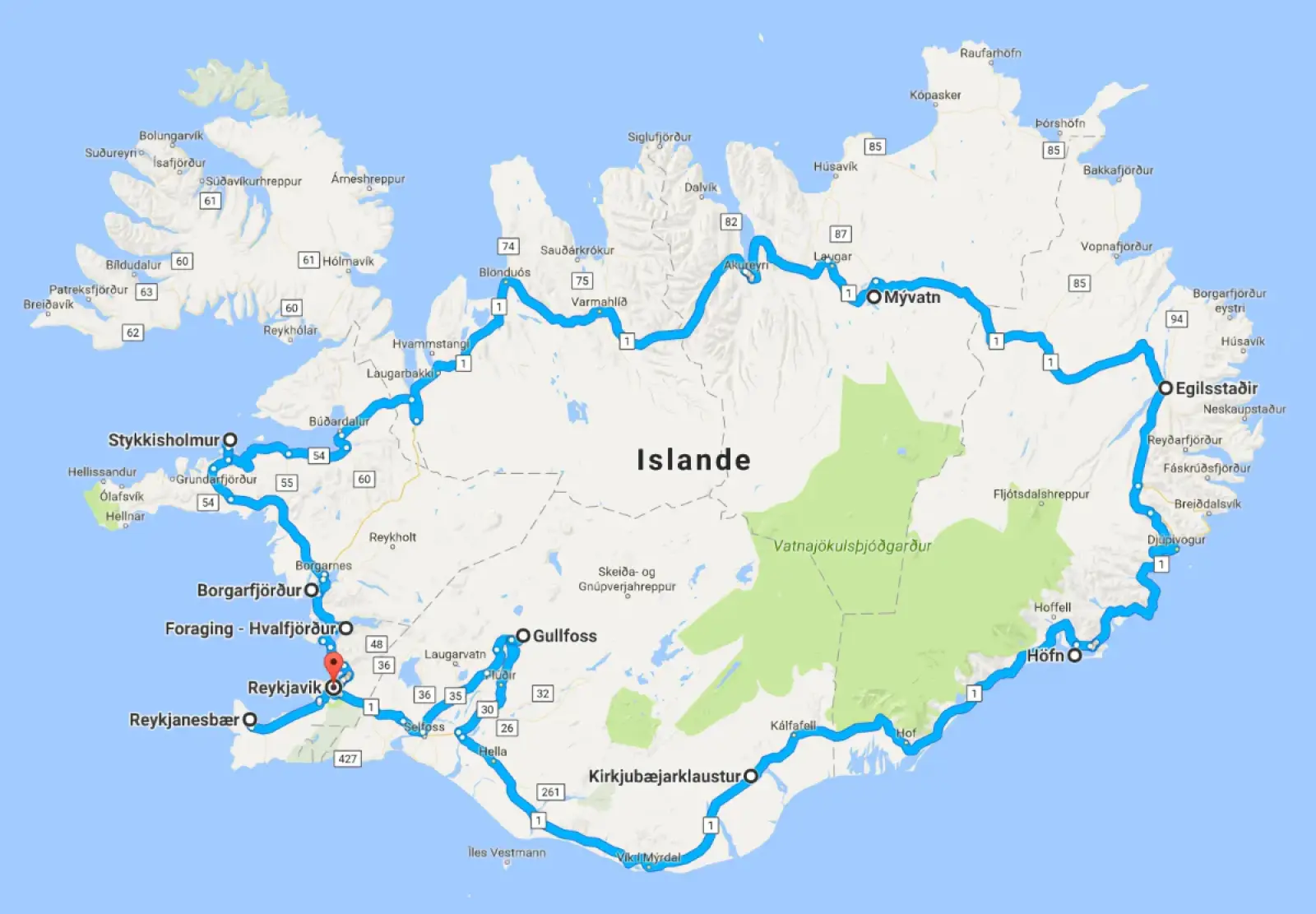 Camping-car stationné face aux montagnes et cascades d'Islande, paysage sauvage en lumière naturelle.